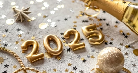 Golden color palette photo with new year 2025 numerals surrounded by confetti and decorations.