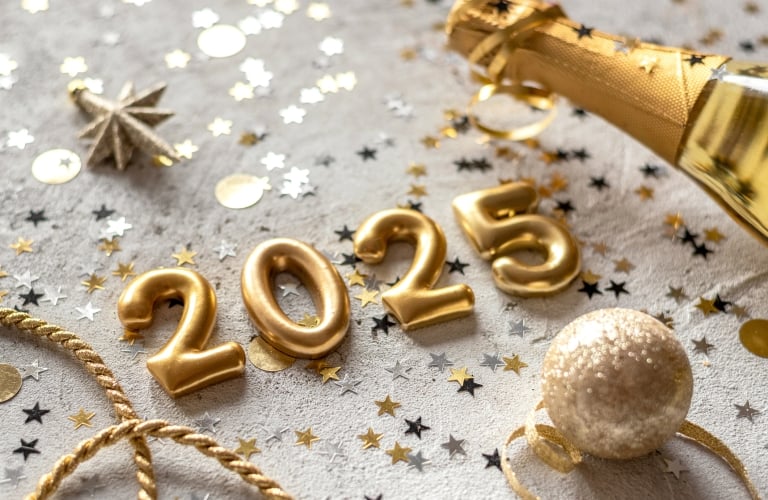 Golden color palette photo with new year 2025 numerals surrounded by confetti and decorations.